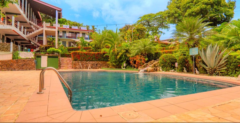 Pool at Hotel Divisamar with tiered tropical gardens and the hotel's room blocks behind