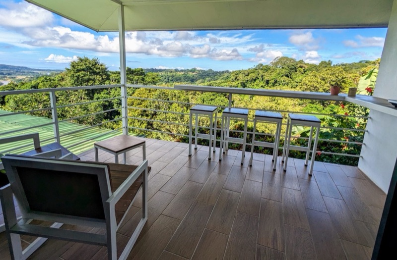 Covered terrace at Rancho Capulin looking over forested hills toward the coast